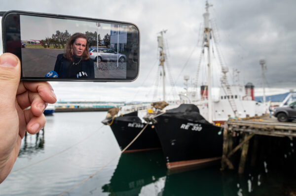 Svandís Svavarsdóttir on screen in front of Hvalur hf ships / Boris Niehaus