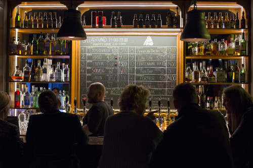 An interior of a bar with a chalk board displaying Icelandic Craft Beer